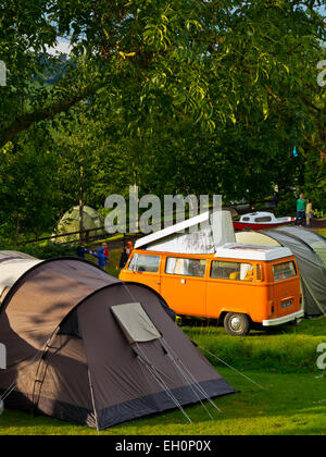 Orange VW camper e tende a gancio Agriturismo Campeggio Uplyme sul Dorset confine Devon England Regno Unito Foto Stock