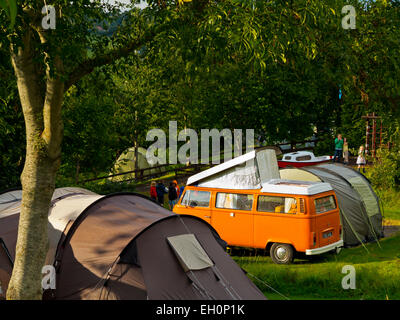 Orange VW camper e tende a gancio Agriturismo Campeggio Uplyme sul Dorset confine Devon England Regno Unito Foto Stock