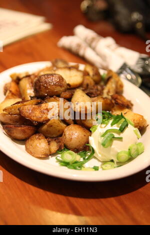 Patate fritte cunei con panna acida Foto Stock