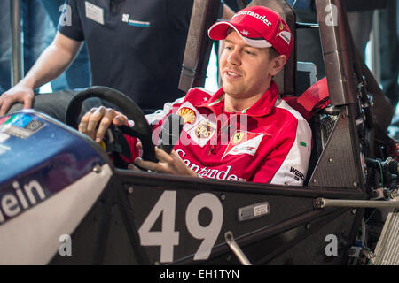 Moenchengladbach, Germania. 05 Mar, 2015. Driver Ferrari Sebastian Vettel si siede in una macchina da corsa che gli studenti della Technische Hochschule Niederrhein hanno progettato per la "Formula Student', e si mette al volante, Moenchengladbach, Germania, 05 marzo 2015. Nella sede centrale della banca di Santander, Vettel ha dato consigli sul concorso internazionale "Formula Student' per gli studenti. Foto: MAJA HITIJ/dpa/Alamy Live News Foto Stock