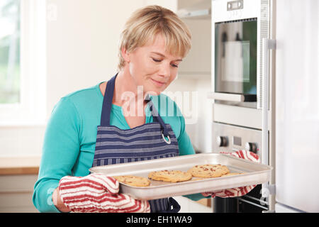 La donna in cucina tenendo il vassoio con Home Biscotti Foto Stock