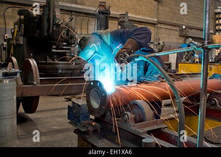 Saldatrice industriale con torcia e guanti di protezione Foto Stock