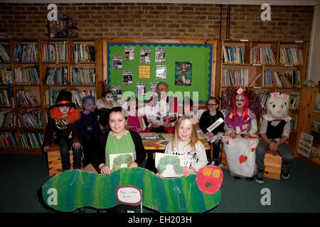 Gli alunni dress up per la Giornata Mondiale del libro 2015 a Biggin Hill scuola primaria e pongono in biblioteca Foto Stock