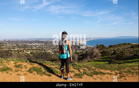 Escursionista guarda alla Baia di Santa Monica dal fuoco strada in Topanga parco dello stato raggiunto via Los Leones Trail (chiamato anche Los Liones) Foto Stock