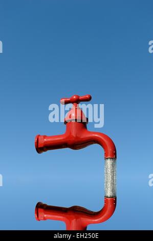 Un rosso acceso industriale tocca fontana insieme contro un cielo blu,specchiata digitalmente Foto Stock