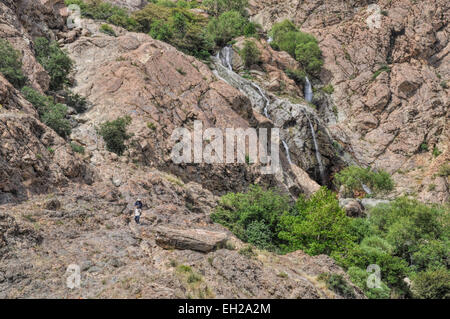 Acqua a cascata verso il basso la scenic pendii rocciosi in Tochal, Iran Foto Stock