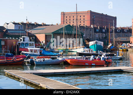 Vista generale di Underfall Yard in Bristol si vede attraverso l'acqua con barche in primo piano. Foto Stock