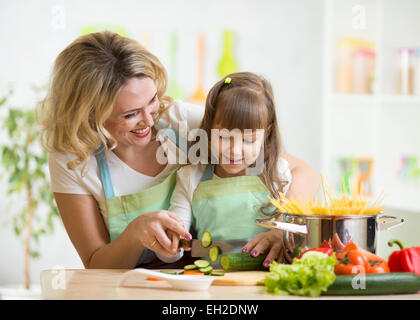 La Madre insegna la figlia per la cottura su cucina Foto Stock