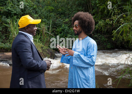 Dr Joseph Oye spiega al calciatore Benoit Assou-Ekotto, come cecità fluviale è diffusa da una mosca vicino a torrenti. Foto Stock