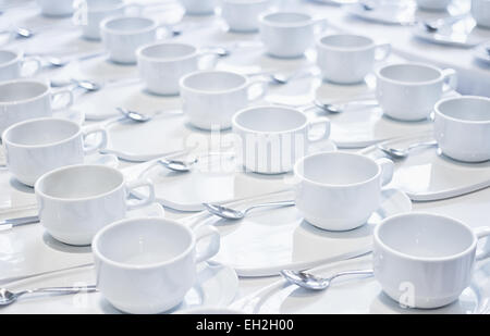 Le pile di tazze da caffè con argento cucchiaini di preparare per la riunione Foto Stock