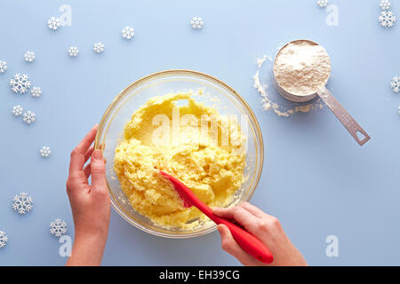 Vista aerea della donna e delle sue mani lo zucchero di agitazione pastella di Cookie Foto Stock