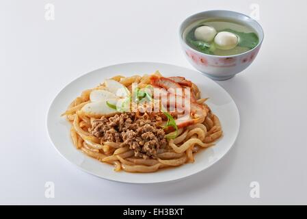 Spaghettini fritti con arrosto di maiale tagliata a fette di torta di pesce di carne macinata di maiale e fishball zuppa in sfondo pulito Foto Stock