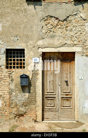 Facciata di un abbandonato e danneggiato vecchia casa con porta di legno Foto Stock