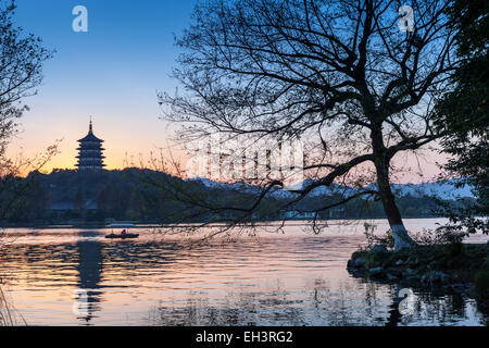 Nero silhouette di alberi e tradizionale pagoda Cinese sulla costa del Lago Ovest. Famoso Parco in Hangzhou city centre, Cina Foto Stock
