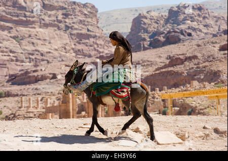 PETRA, GIORDANIA - Ott 12, 2014: un asino con il suo proprietario sul suo cavallo in Petra in Giordania Foto Stock