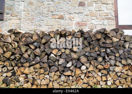 Un trito di legno in giardino impilati per essere utilizzato per il posto del fuoco Foto Stock