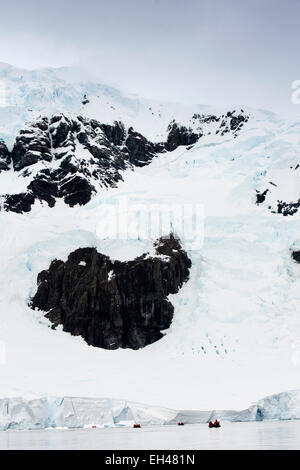 L'Antartide, Paradise Bay, la nave di crociera i passeggeri di crociera in zodiac alla fine del ghiacciaio Foto Stock