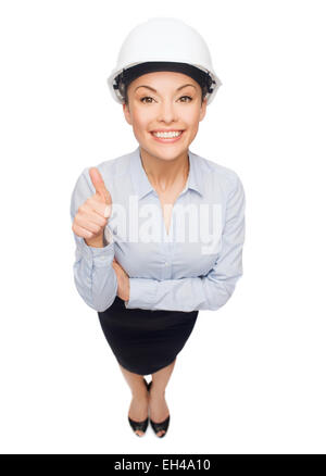 Imprenditrice nel casco bianco che mostra pollice in alto Foto Stock