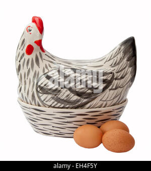 Uovo di ceramica contenitore a forma di gallina, foderato con paglia e contenenti uova di colore marrone. Foto Stock