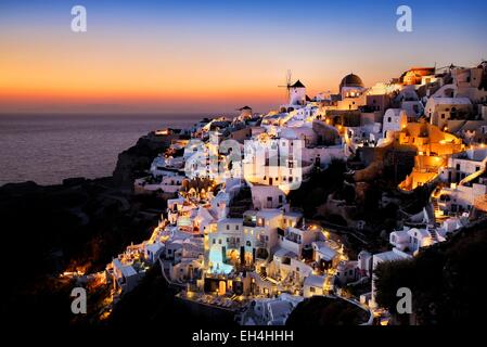 Grecia CICLADI Santorini Island (Thera, Thira), mulini a vento e il villaggio di Oia al tramonto Foto Stock