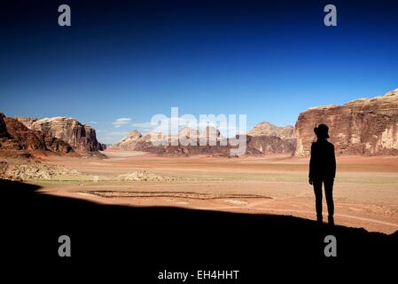 Giordania, Wadi Rum desert, area protetta elencati come patrimonio mondiale dall' UNESCO, silhouette di donna e di deserto di sabbia rossa da Jebel Qattar Foto Stock