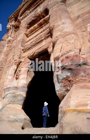 Giordania, Nabataean sito archeologico di Petra, elencato come patrimonio mondiale dall' UNESCO, donna all'ingresso di un reale tomba scavata nella montagna Foto Stock