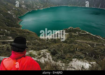 Ecuador, Cotopaxi, Lago di Quilotoa, donna ecuadoriana contemplando una laguna nel cratere di un vulcano estinto Foto Stock