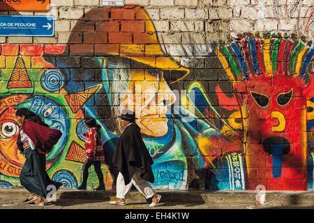 Ecuador, Imbabura, Peguche, famiglia ecuadoriana camminando su un marciapiede davanti al muro di graffiti Foto Stock