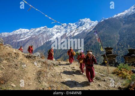 Il Nepal, Gandaki zona, Tsum valley trek, giovani monaci buddisti, il Ganesh Himal gamma in background Foto Stock