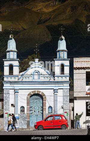 Ecuador, Imbabura, Atuntaqui, rosso auto parcheggiate al di fuori di una chiesa su un sfondo di montagna Foto Stock