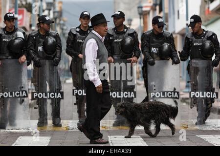 Ecuador, Imbabura, Cotacaxi, Intyrami giorno, vecchio uomo passato il cordone di polizia durante le feste Foto Stock