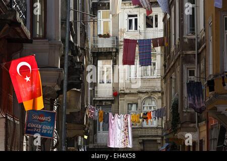 Turchia, Istanbul, Beyoglu, Galata, paesaggio urbano di asciugare i panni in una zona popolare, bandiera della nazione turca in primo piano Foto Stock