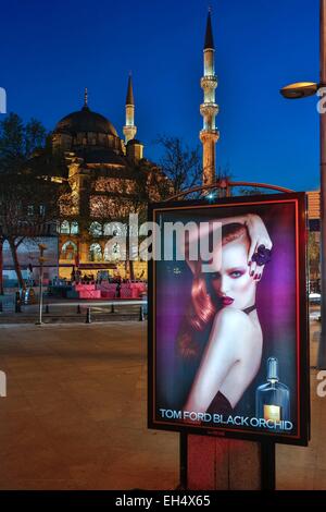 Turchia, Istanbul, centro storico elencati come patrimonio mondiale dall' UNESCO, Eminönü district, La Yeni Cami (Nuova Moschea), vista notturna della moschea informati Yeni dietro un cartellone pubblicitario di un sapore Europeo Foto Stock