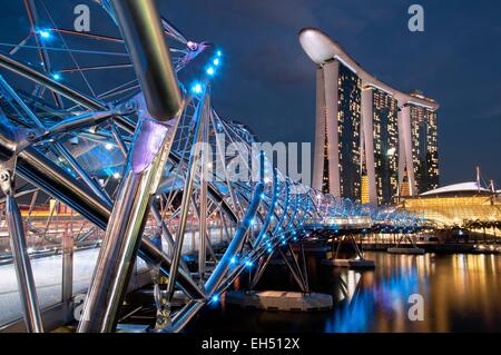 Singapore, Marina Bay, Marina Bay sands hotel progettato dall architetto Moshe Safdie in serata, vista dal ponte di Helix Foto Stock