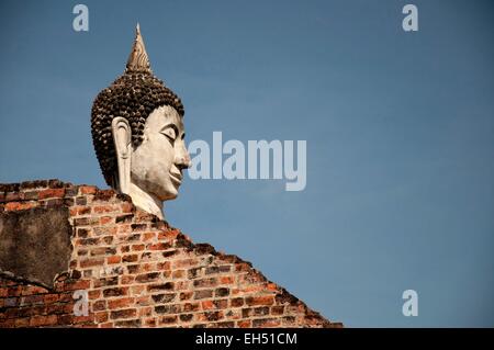 Thailandia, Ayutthaya elencati come patrimonio mondiale dall' UNESCO, Wat Yai Chai Mongkol, la testa di una statua di pietra di Buddha di rosso e un muro di mattoni Foto Stock