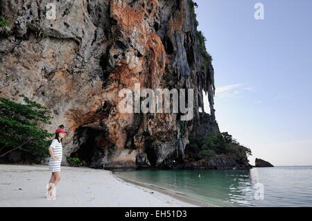 Thailandia, Krabi, Railay, Hat Phra Nang, il famoso Phra Nang Beach a Railay, giovane donna di fronte alla scogliere calcaree (modello di rilascio) Foto Stock