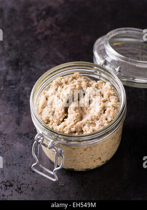 Paté di funghi in un vaso su sfondo scuro, il fuoco selettivo Foto Stock