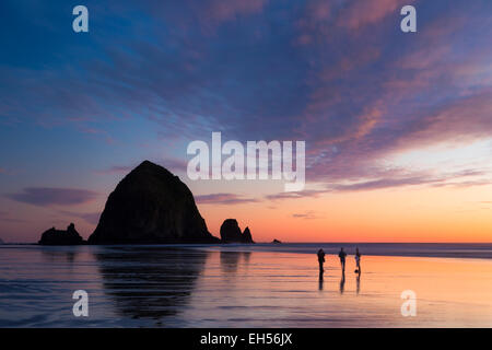Sunset over Haystack Rock lungo la costa dell'Oregon a Cannon Beach, Stati Uniti d'America Foto Stock