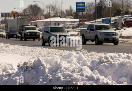 Lexington, Kentucky, Stati Uniti. 6th marzo, 2015. Il traffico in direzione ovest passa nella neve accumulata nella mediana di New Circle Road a Lexington. Dopo la storica nevicata e le temperature notturne subzero hanno portato alla seconda dichiarazione di emergenza a livello statale in poco più di due settimane, la temperatura si è riscaldata leggermente al di sopra del congelamento il Venerdì e si prevedeva di continuare a salire nei giorni a venire. (Apex MediaWire Foto di Billy Suratt) Foto Stock
