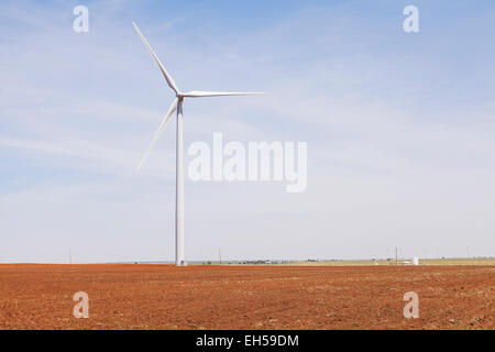 Il mulino a vento per la generazione di elettricità in appena arati campo di fieno con calore sfarfallare, Kiowa County, Oklahoma Foto Stock