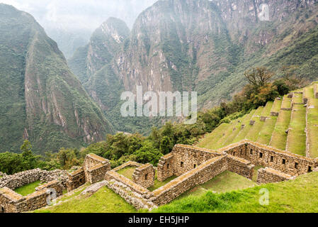 Vista delle terrazze e rovine e Machu Picchu con montagne delle Ande in background Foto Stock