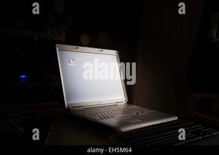 Un computer notebook Dell in una stanza buia con Windows Vista screen saver attivo Foto Stock
