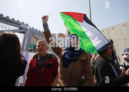 (150308) -- RAMALLAH, 8 marzo 2015 (Xinhua) -- Una donna Palestinese sventola una bandiera nazionale durante una manifestazione di protesta a Qalandiya checkpoint in Cisgiordania città di Ramallah, 7 marzo 2015. (Xinhua/Fadi Arouri) (zjy) Foto Stock