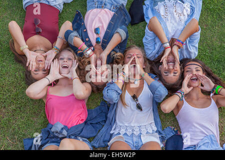 Un gruppo di ragazzi che grida o cantando con le mani a tazza Foto Stock