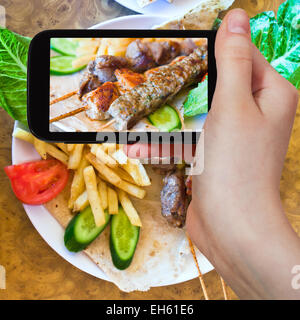 Fotografare il concetto di cibo - turistica prendendo foto di spiedini mix arabo spiedini su gadget mobile, Giordania Foto Stock