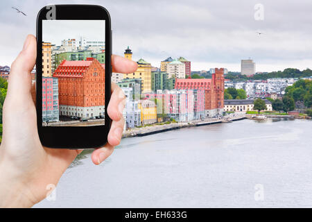 Concetto di viaggio - turistica prendendo foto di waterfront a Stoccolma in Svezia su gadget mobile Foto Stock