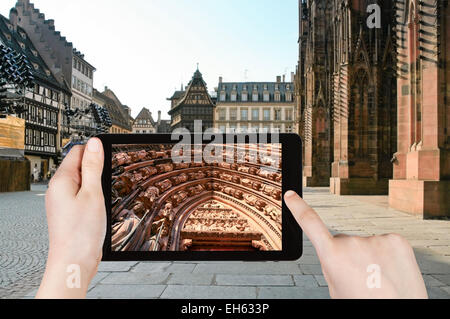 Concetto di viaggio - turistica prendendo foto della cattedrale di Strasburgo, Francia sul gadget mobile Foto Stock