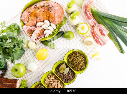 La pancetta affumicata con la carne di maiale con verde insalata sana e varie erbe sulla tovaglia tavola vista superiore Foto Stock