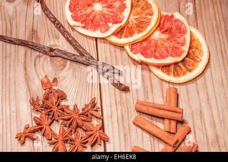 Frutta secca, vaniglia- e bastoncini di cannella e stella anis. Su sfondo di legno Foto Stock