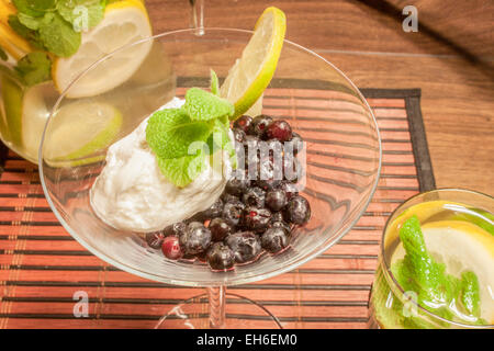 Blueberrys e quark con la menta, stando in piedi in un bicchiere su un tablet Foto Stock